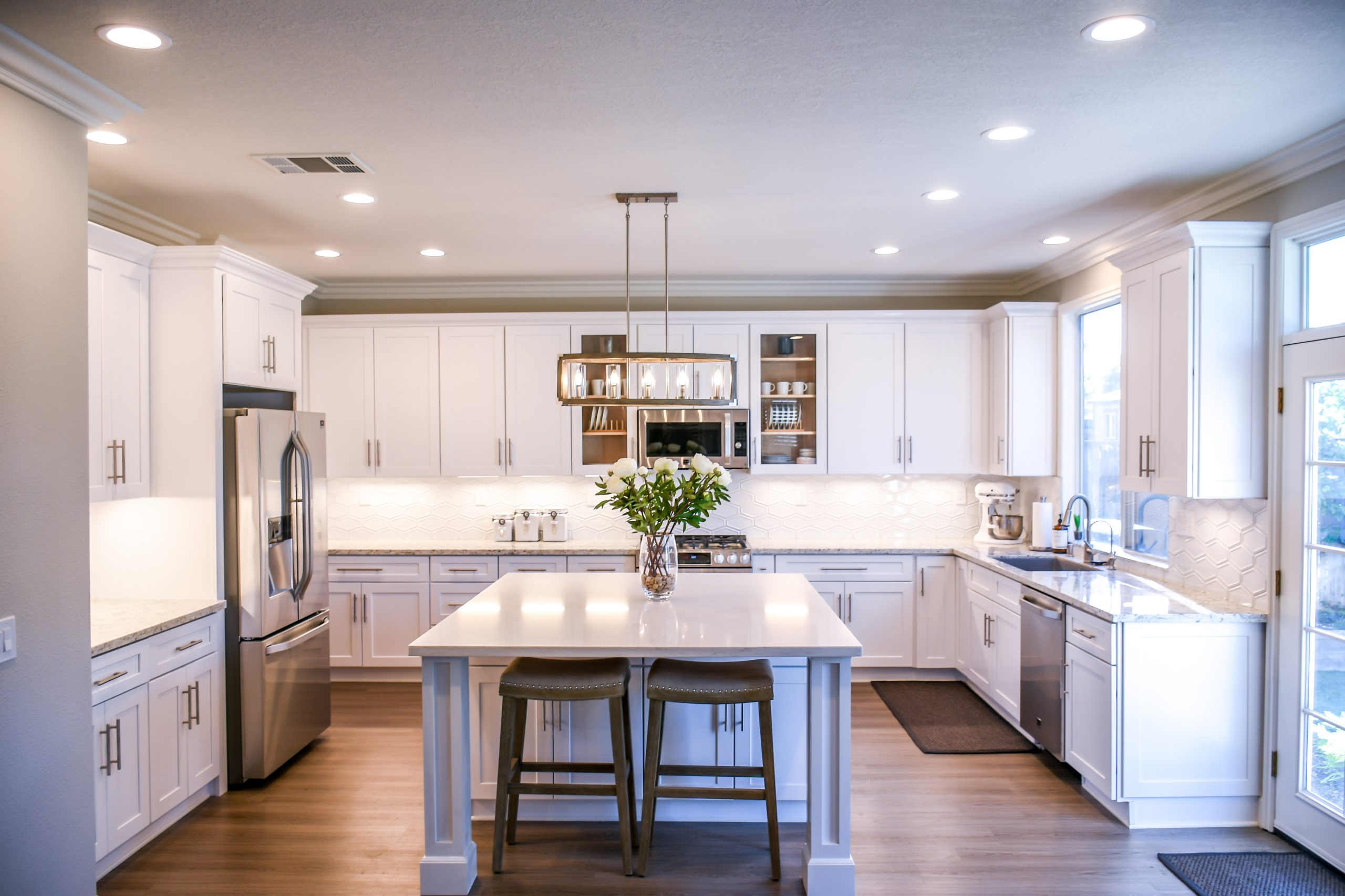 A modern, white kitchen with a large island