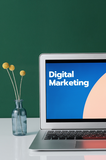 Laptop on a table with words “digital marketing” written on it.