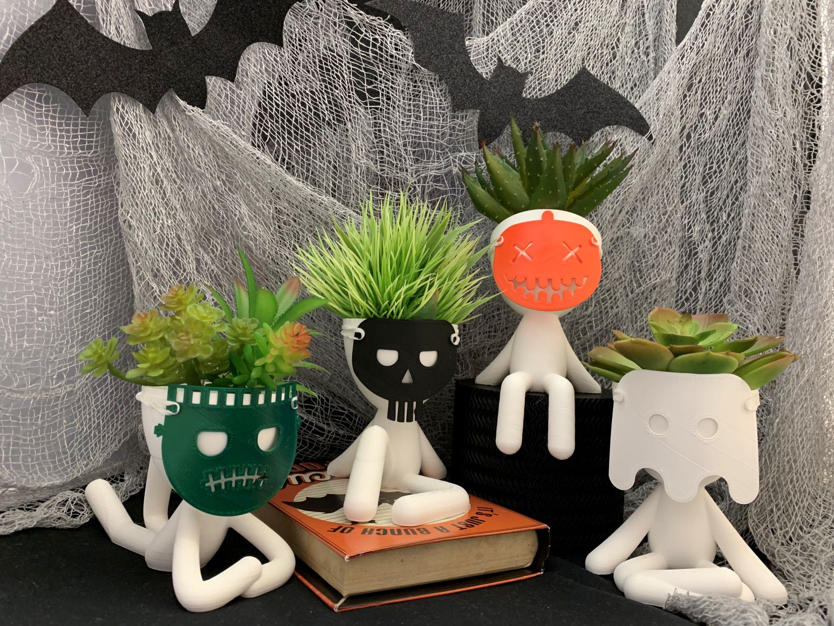 The Big Bob planter pots don on Halloween masks.