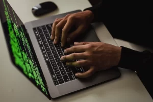 A hacker typing codes on a laptop.