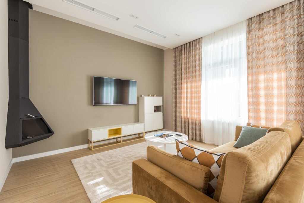A lovely room with a white carpet at the center beneath a glass coffee table. Working with Carpets