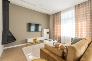 A lovely room with a white carpet at the center beneath a glass coffee table. Working with Carpets