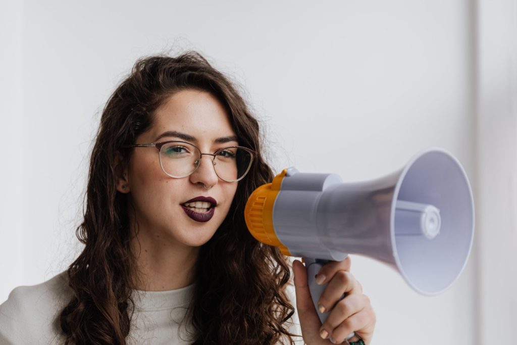 A woman doing content amplification with a megaphone.