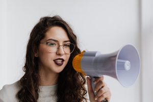 A woman doing content amplification with a megaphone.