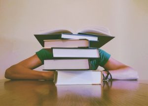 woman behind stack of books paying off law school debt