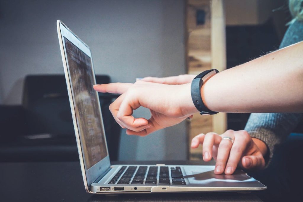 hands pointing at laptop screen the importance of seo in digital marketing