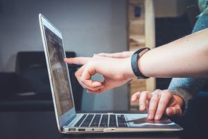hands pointing at laptop screen the importance of seo in digital marketing