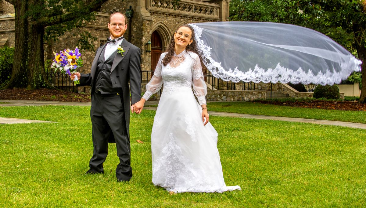 lovely picture of groom and bride with veil floating in the air showcasing the importance of wedding photography