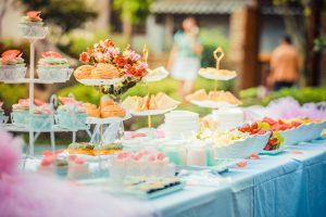 A variety of fruits and pastries set decoratively on a blue table.