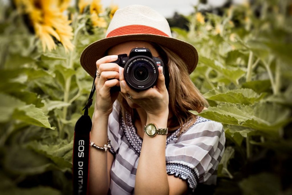 A woman taking a photo with a camera, showcasing the top photography trends.