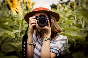 A woman taking a photo with a camera, showcasing the top photography trends.