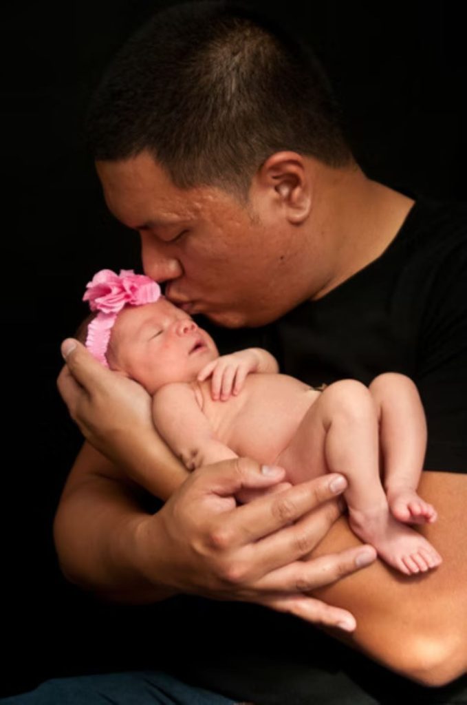 A father cradling his daughter.